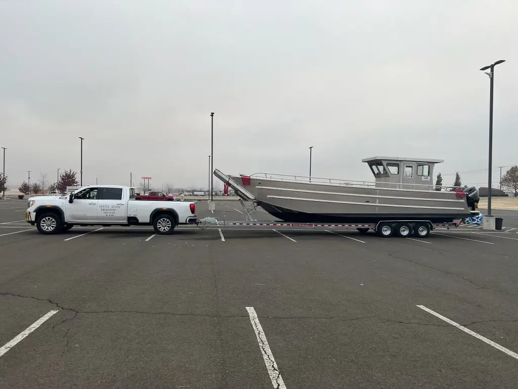 A truck pulling a boat in the back of it.